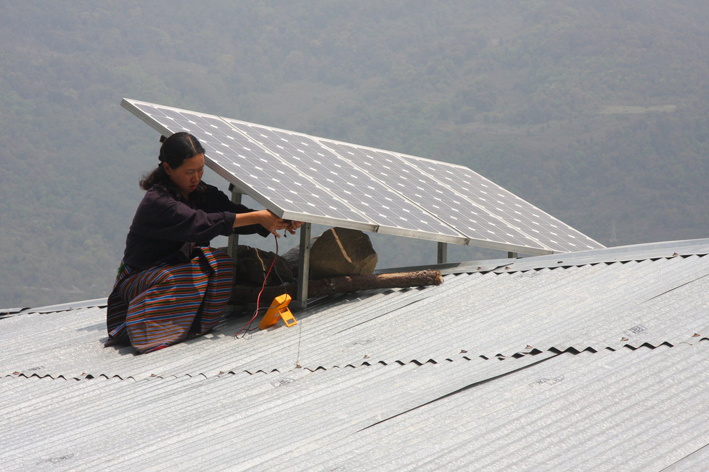 Access to electricity is a major challege for communities in landlocked developing countries. Pictured here, a family installs a solar panel on a roof in Bhutan.